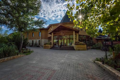 a building with a brick driveway in front at Session Hotel Ráckeve in Ráckeve