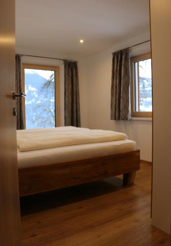 a bedroom with a bed and a window at Ferienwohnung Därflihof in Bartholomäberg