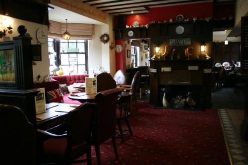 a restaurant with tables and chairs and a fireplace at The Angel Inn (Blyth) in Blyth