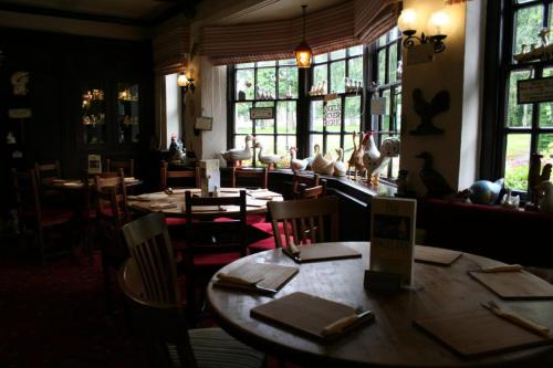 a dining room with tables and chairs and windows at The Angel Inn (Blyth) in Blyth