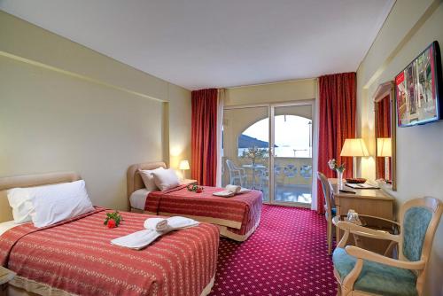 a hotel room with two beds and a balcony at Angelika Pallas Hotel in Igoumenitsa
