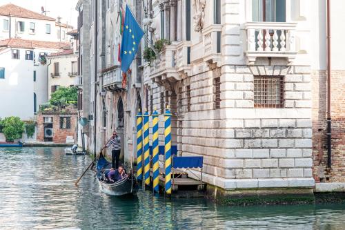 a man in a gondola in a canal next to a building at Hotel Ai Cavalieri di Venezia in Venice