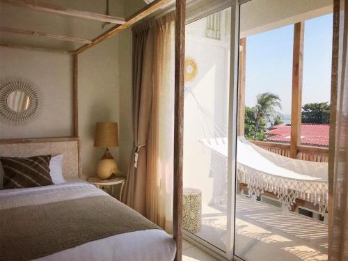 a bedroom with a bed and a balcony with a hammock at Villa S in Hua Hin
