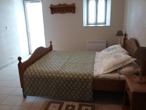 ein Schlafzimmer mit einem Bett in einem Zimmer mit Fenstern in der Unterkunft La Ferme Du Vincin in Vannes