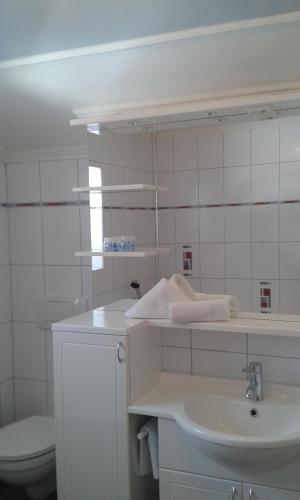 a white bathroom with a sink and a toilet at Alpin Appart Reiterhof in Niederthai