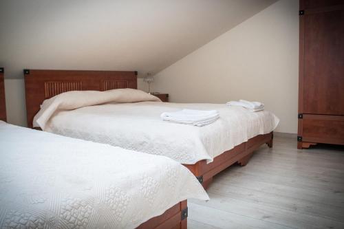 a bedroom with two beds with white linens at Pokoje Nad Arkadami in Zamość