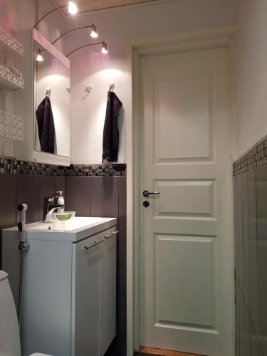 a bathroom with a white door and a sink at Arctic Red House in Rovaniemi