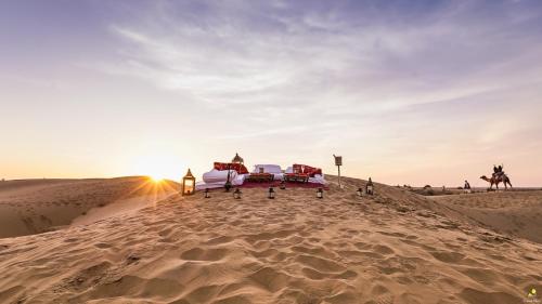 a sand dune with a bed in the middle of a desert at Dhora Desert Resort, Signature collection by Eight Continents in Shaitrāwa