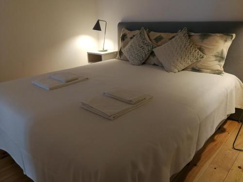 リスボンにあるChiado downtown apartmentの白い大型ベッド(折りたたみ式タオル2枚付)