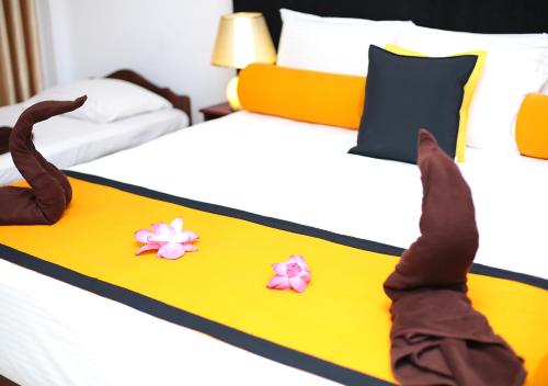 a person laying on a bed with flowers on it at Celestial Inn in Mirissa