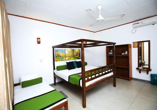 a bedroom with two bunk beds and a ceiling fan at Celestial Inn in Mirissa