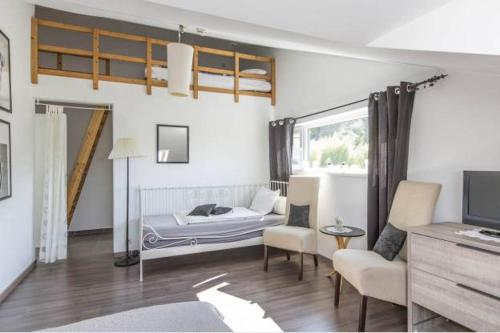 een slaapkamer met een bed, een bank en een tv bij La Villa Coocon in Trois-Ponts