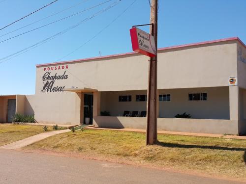 a white building with a sign in front of it at Pousada Chapada das Mesas in Riachão