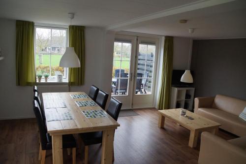 a living room with a table and chairs and a couch at Vakantiehuizen Hofstede Elzenoord in Vrouwenpolder