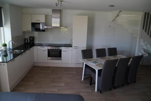 a kitchen with a table and chairs in a room at Vakantiehuizen Hofstede Elzenoord in Vrouwenpolder