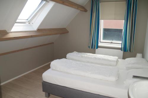 フラウウェンポルデルにあるVakantiehuizen Hofstede Elzenoordのベッド1台、洗面台、窓が備わる客室です。