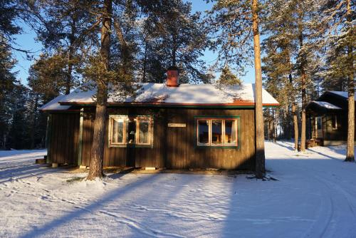 una pequeña casa en la nieve en el bosque en Stena Cabins & Apartments, en Äkäslompolo