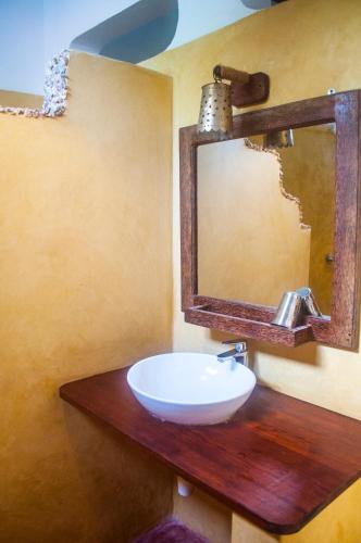 a bathroom with a sink and a mirror at Atii Garden Bungalows in Nungwi