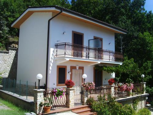 a small white house with a balcony and flowers at Casa Lieta in Subiaco