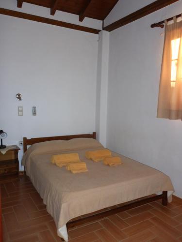 um quarto com uma cama com toalhas amarelas em Studios Resbithas em Gytheio