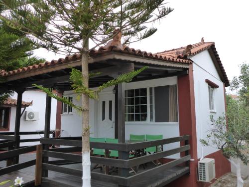 a small white house with a tree in front of it at Studios Resbithas in Gythio