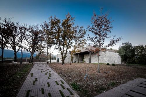 a building in the middle of a field with trees at Palazzo Tronconi agriturismo in Arce