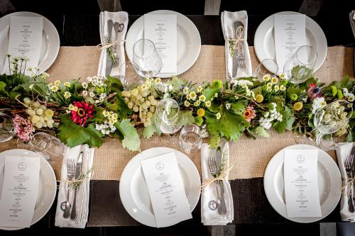 una mesa con platos blancos y flores en ella en Palazzo Tronconi, en Arce