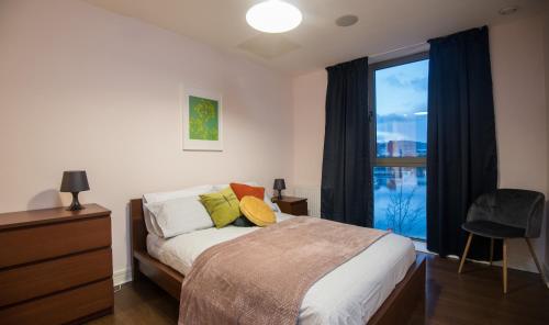 ベルファストにあるTitanic Marina View Apartmentのベッドルーム1室(ベッド1台、大きな窓付)