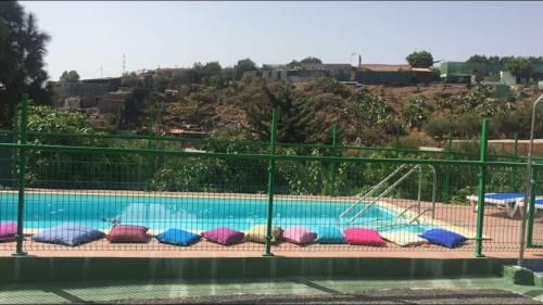 a swimming pool with colorful pillows around it at Aguatona in Ingenio
