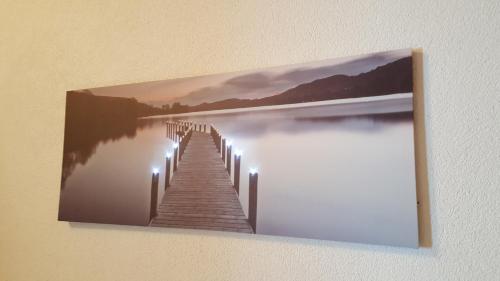 a painting of a dock on a lake with lights at Apartment Greidlerhof in Rohrberg