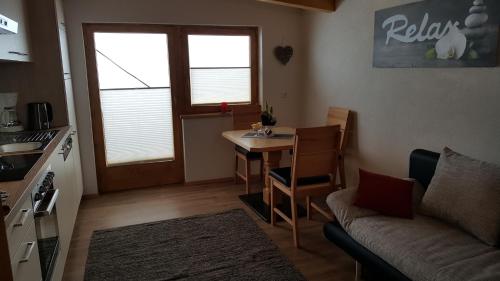 a living room with a table and a couch and a kitchen at Apartment Greidlerhof in Rohrberg