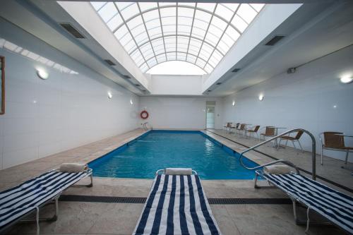 a large swimming pool with a skylight in a building at Hotel Diego de Almagro Lomas Verdes in Concepción
