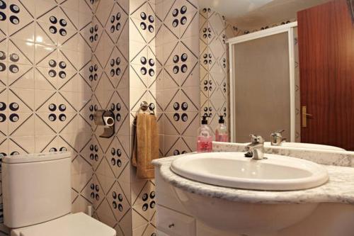 a bathroom with a white sink and a toilet at Apartamento Pau Casals in L'Ametlla de Mar