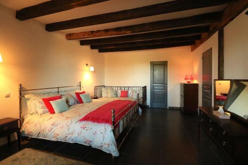 a bedroom with a large bed with red pillows at La Bucherie in Montembœuf