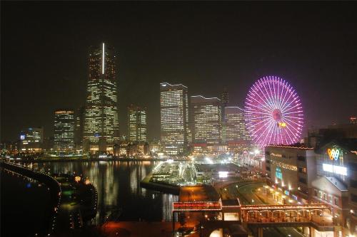 un perfil urbano con una noria por la noche en Navios Yokohama en Yokohama