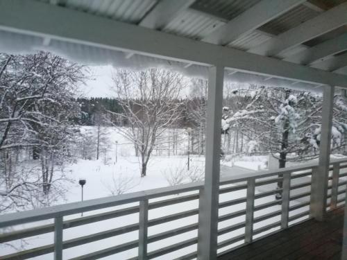 a view of a snow covered yard from a porch at Talvitaival Apartments in Varkaus