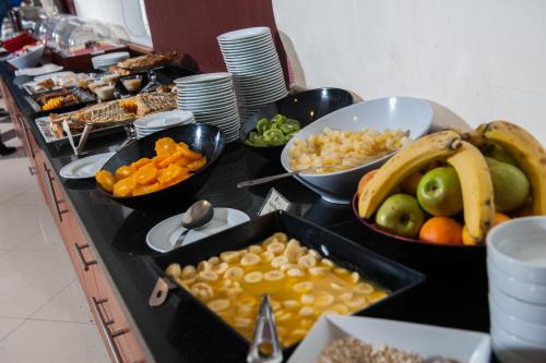 a buffet line with bowls of fruit and other food at Hotel Diego de Almagro Lomas Verdes in Concepción