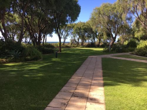 una pasarela en un parque con árboles y césped en Geographe Bay Apartment, en Busselton