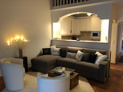 Una sala de estar con un sofá y una cocina. en Perrine Duplex, en Saint-Tropez