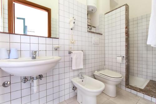 a white bathroom with a sink and a toilet at Hotel Villino Gallodoro in Taormina