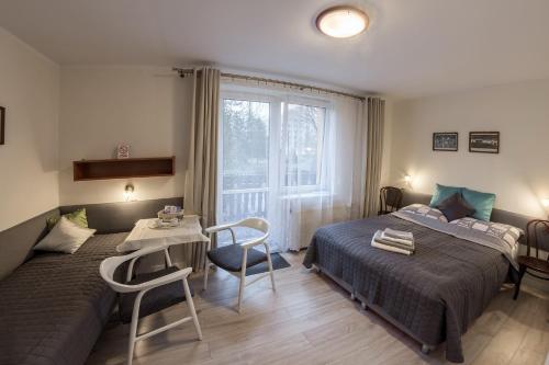 1 dormitorio con 2 camas, mesa y ventana en Willa Ewa, en Ustroń