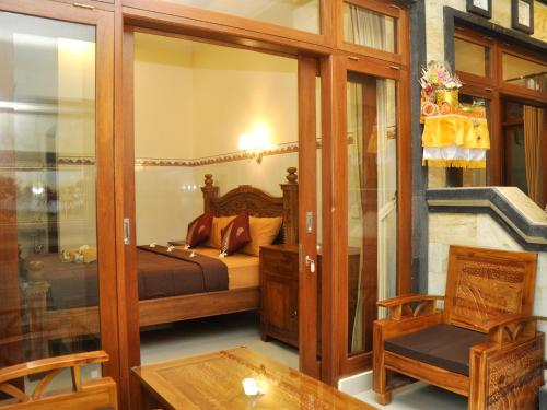 sypialnia z łóżkiem, krzesłem i stołem w obiekcie Mira Family Homestay w mieście Ubud