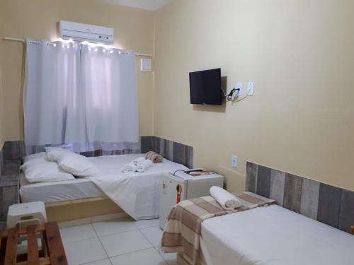 a hospital room with two beds and a tv at Pousada O Tabuleiro in Jacumã