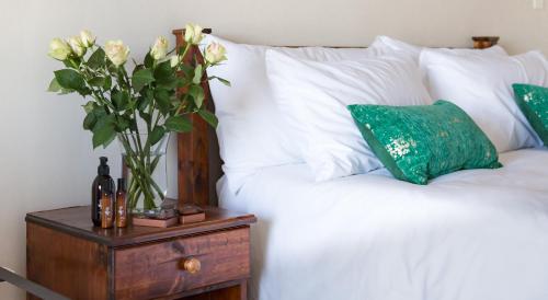 a vase of flowers on a night stand next to a bed at Moncrieff Manor in Knysna