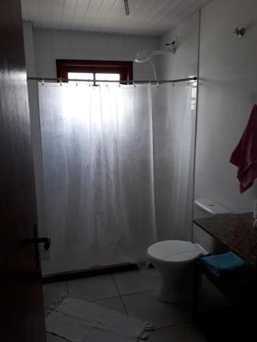 uma casa de banho com um WC e uma cortina de chuveiro em Lindo Apartamento praia e quiosque abertos em Cabo Frio