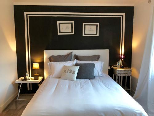 a bedroom with a white bed with a black headboard at Perrine Duplex in Saint-Tropez