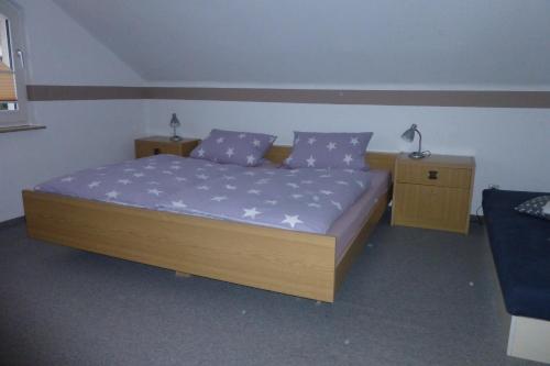una camera da letto con letto con lenzuola viola e 2 comodini di Apartment Schoenblick a Winterberg