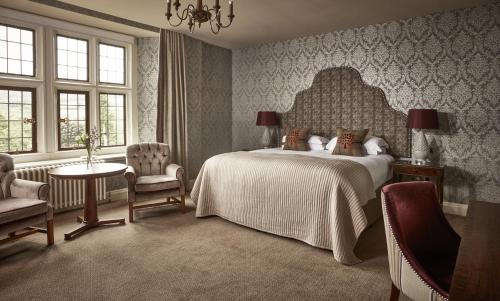a bedroom with a bed and a table and chairs at Bovey Castle in Moretonhampstead