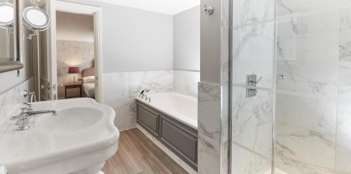 a white bathroom with a sink and a shower at Bovey Castle in Moretonhampstead