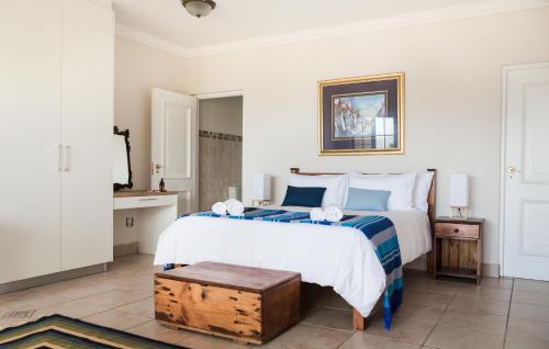 a bedroom with a large bed with blue and white pillows at Moncrieff Manor in Knysna